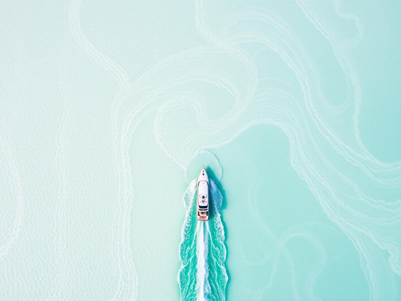 Aerial view of a yacht crossing the pale turquoise Bahamian sandbanks